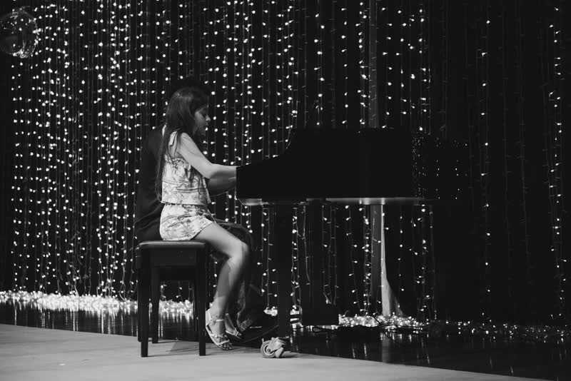 Aluna ao piano de cauda durante a apresentação