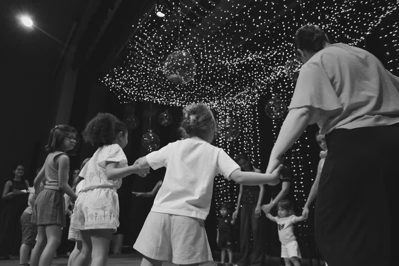Crianças brincando de roda no palco