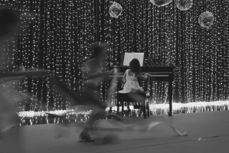 Palco com cortina de luzes e piano ao fundo