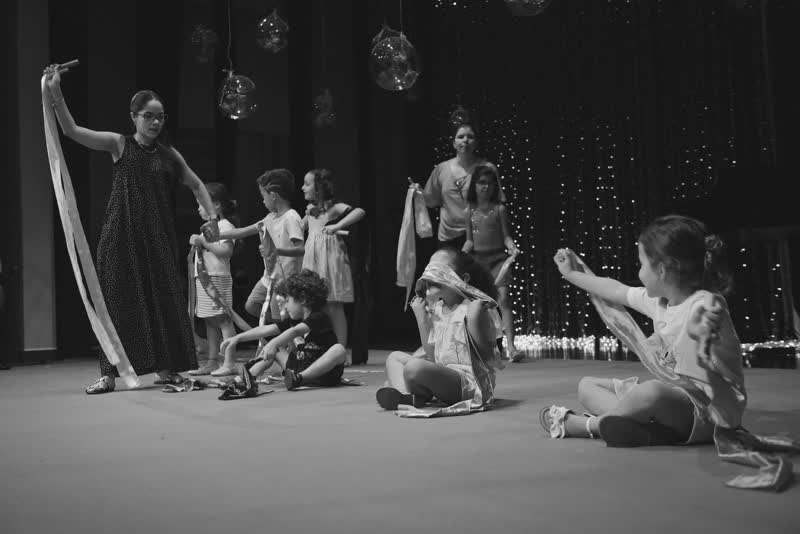 Criança com flor de papel no palco